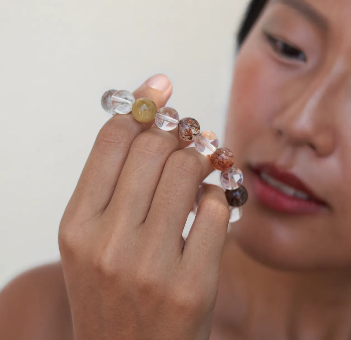 Woman examining a Le Lian quartz bracelet