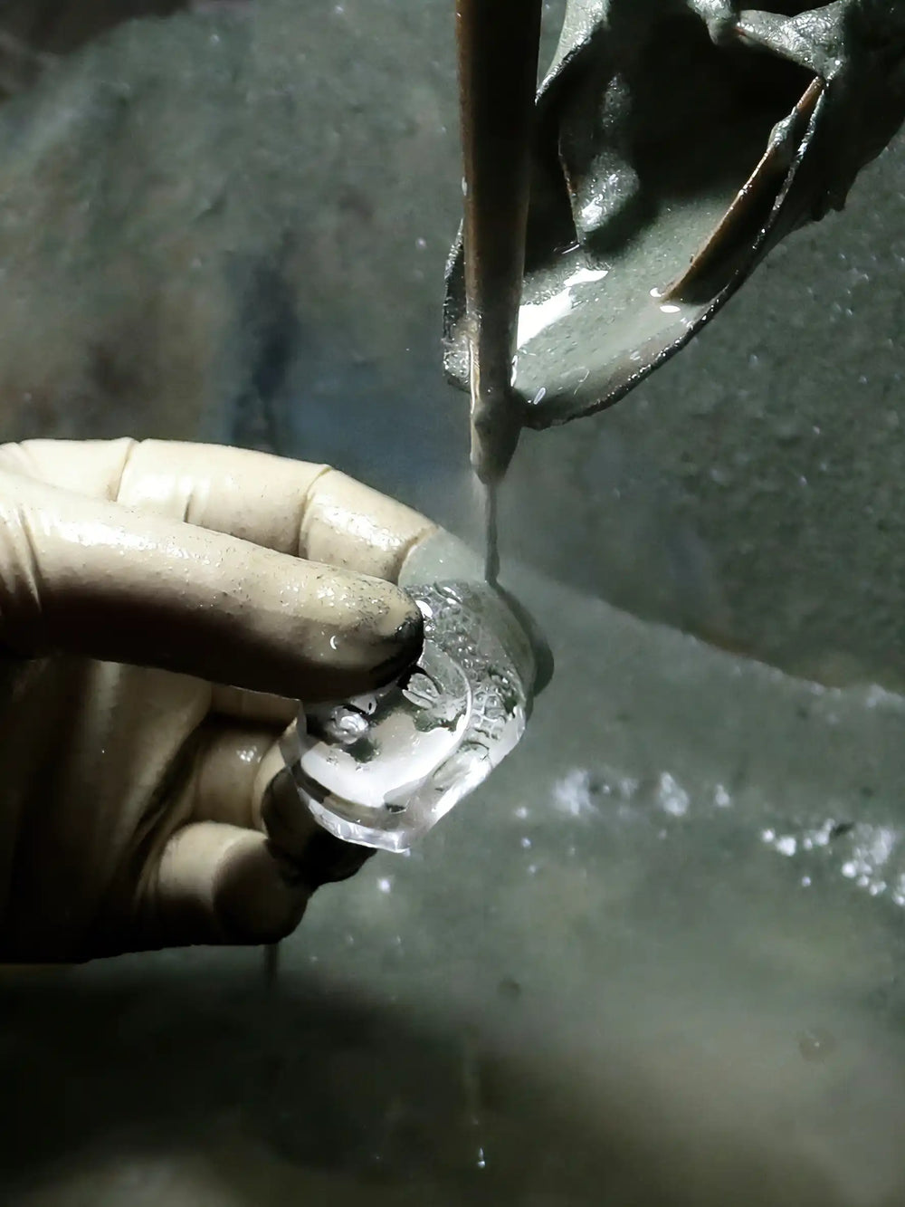 Artisan polishing a crystal piece with water